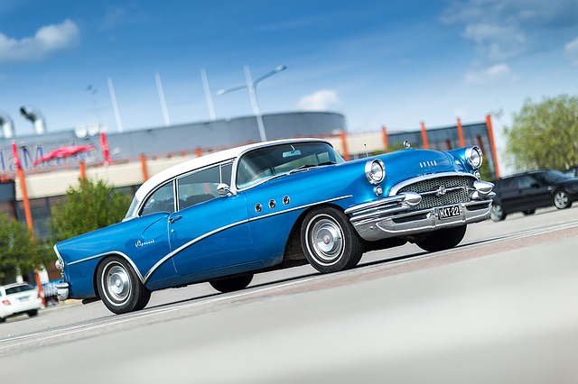 Niebieski oldtimer na parkingu przed centrum handlowym