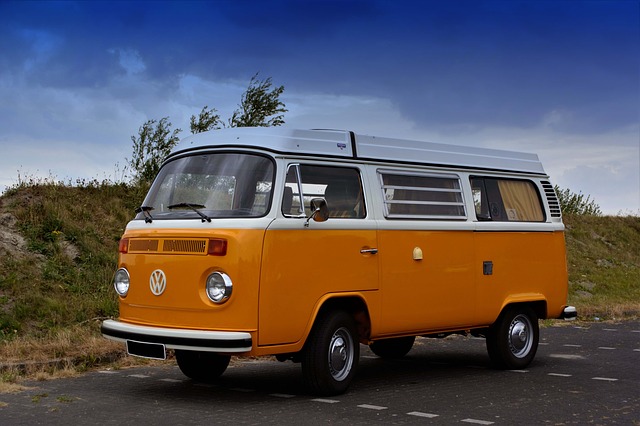 Zabytkowy Volkswagen T1 z 1967 roku w pomarańczowo białym kolorze, na parkingu przy plaży